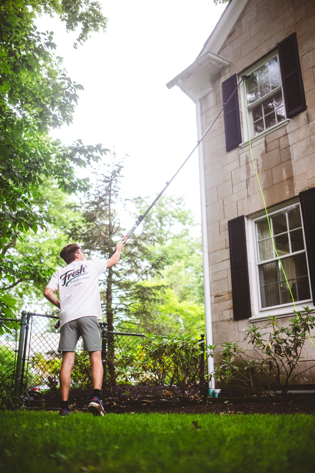 Fresh Windows technician cleaning a Northeast Ohio home's windows with a water-fed pole