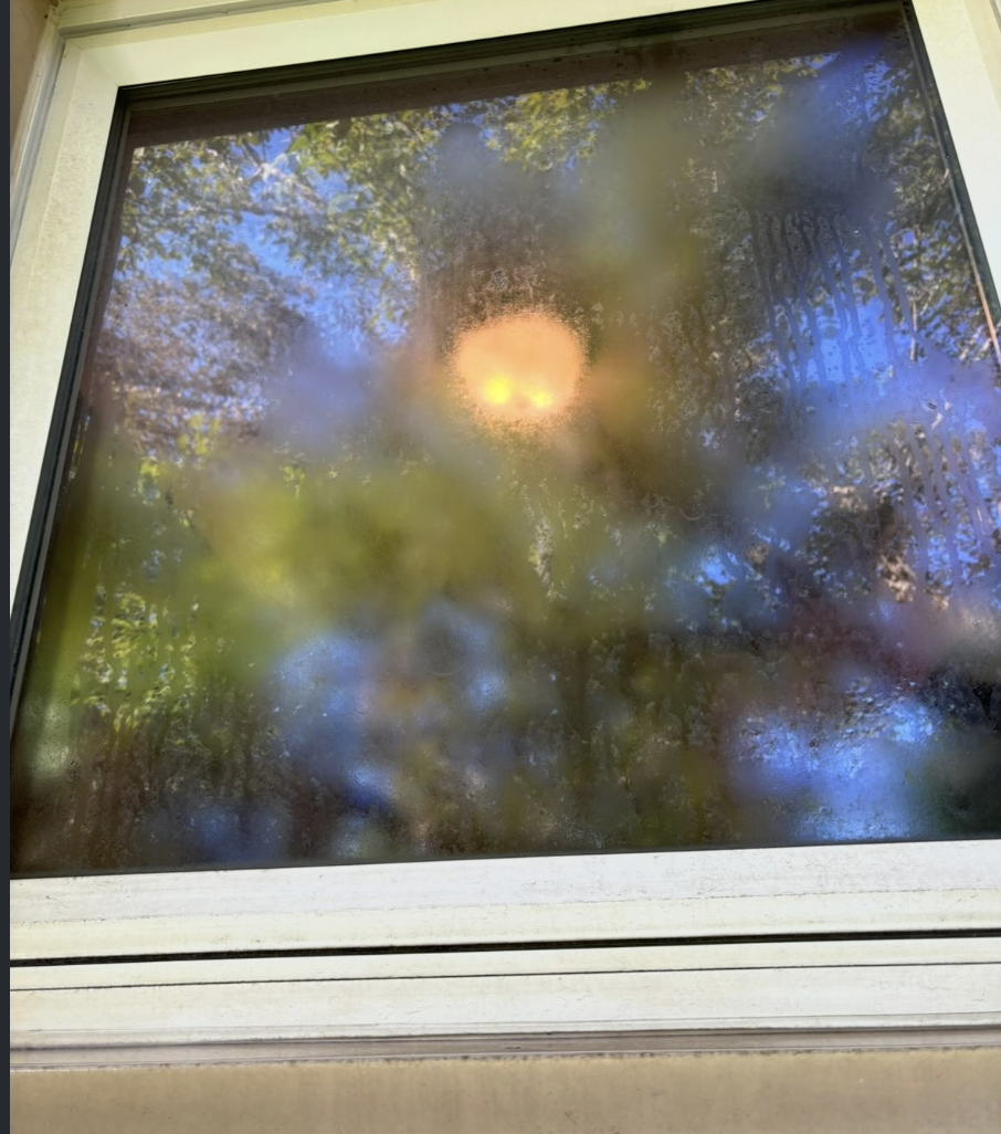 Foggy, hard-water-stained window before Fresh Windows cleaning