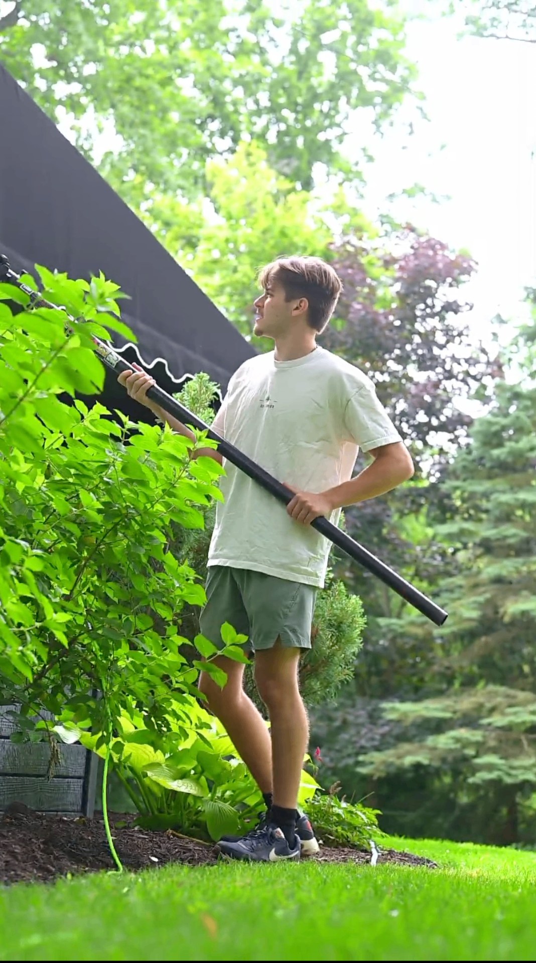 Fresh Windows technician with a water-fed pole in a Northeast Ohio yard